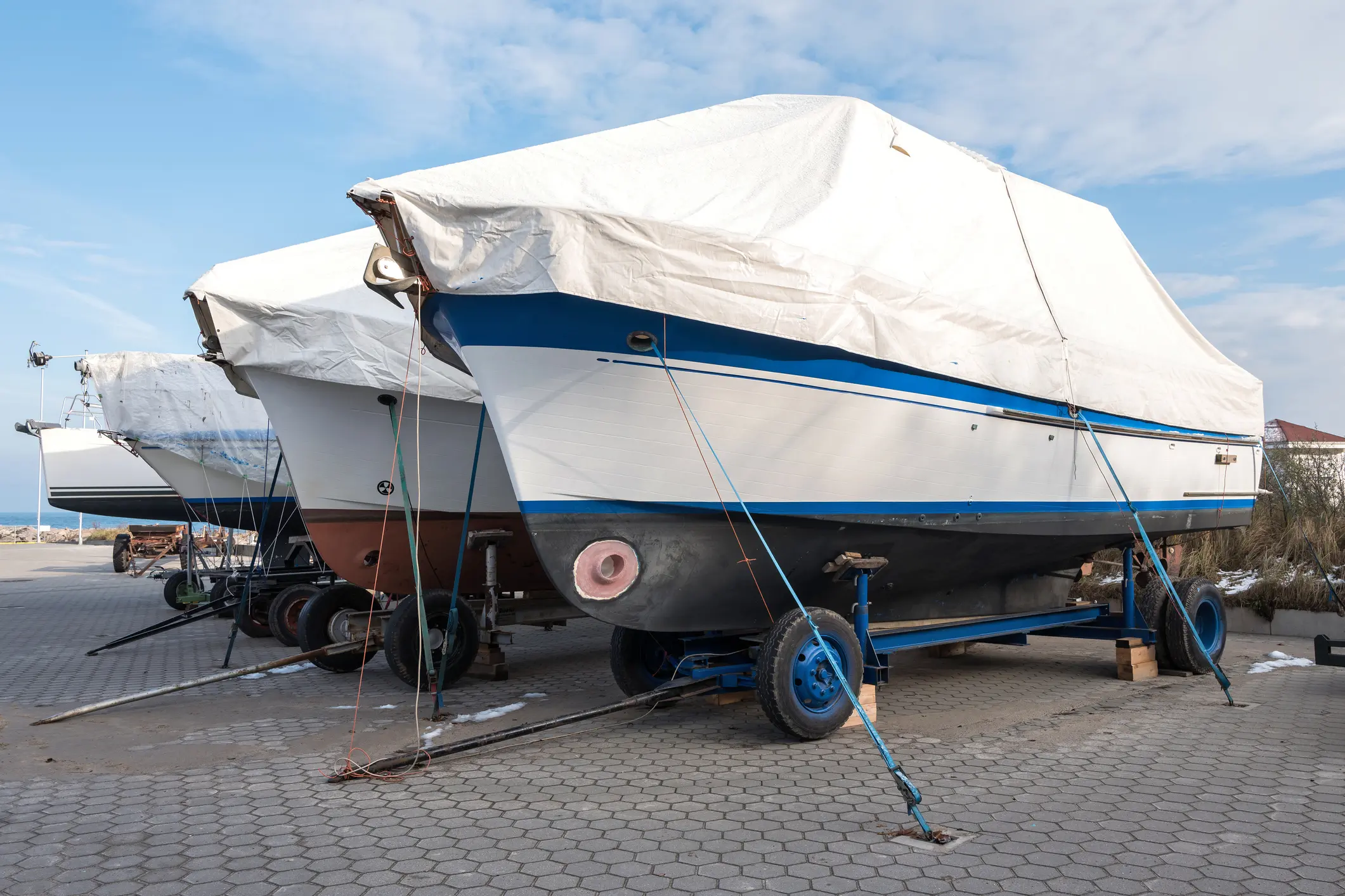 Boats covered and stored on land.