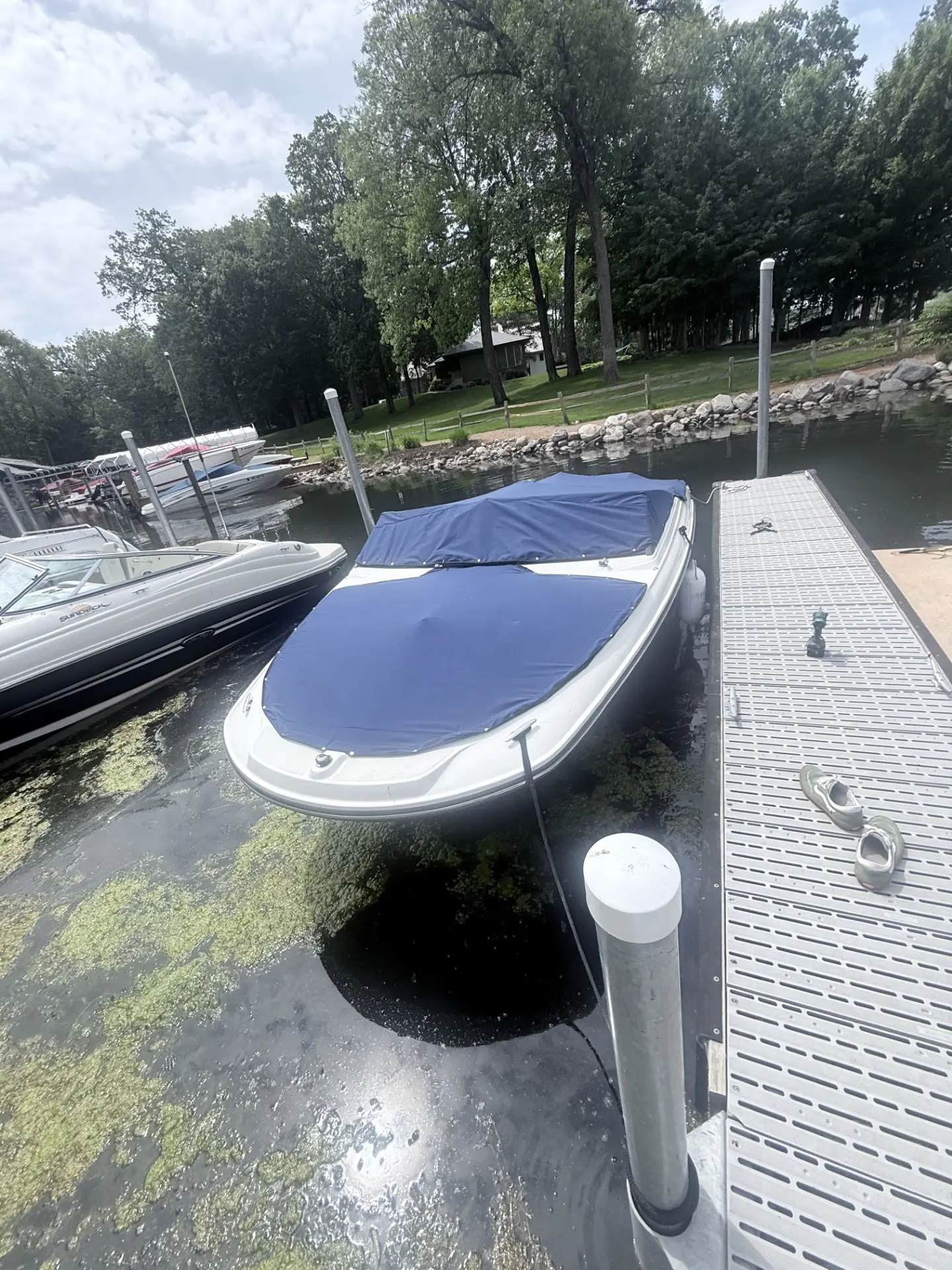 Boat docked with blue cover at marina.