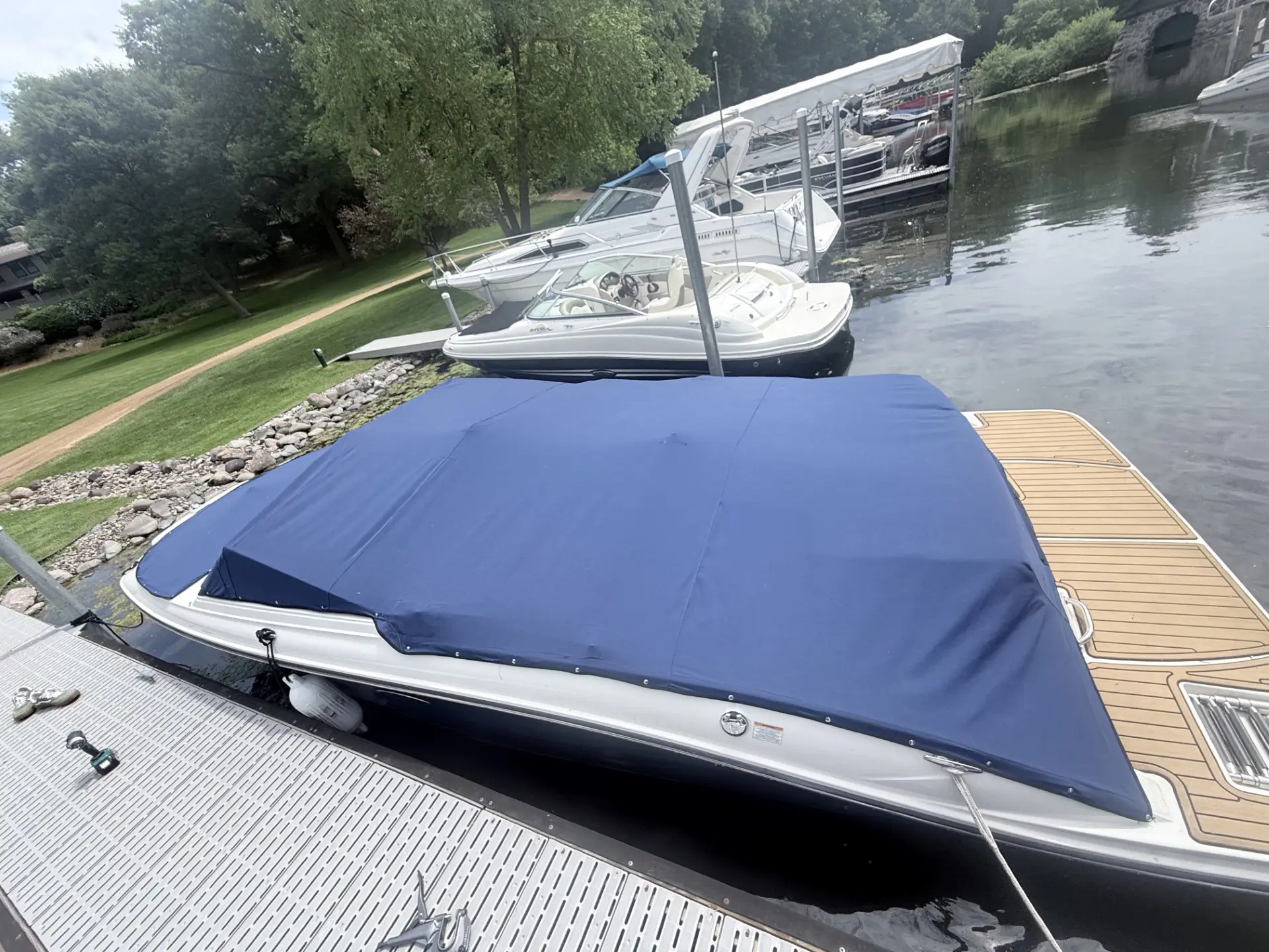 Boat with blue cover docked at marina.